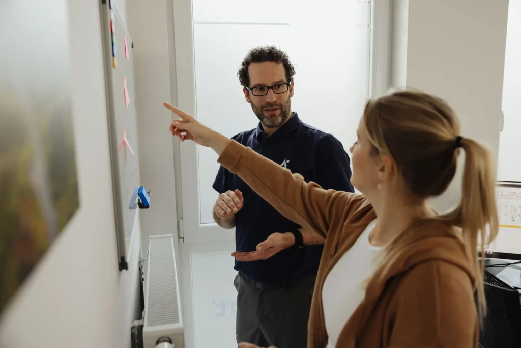 Patientin zeigt auf etwas am Whiteboard