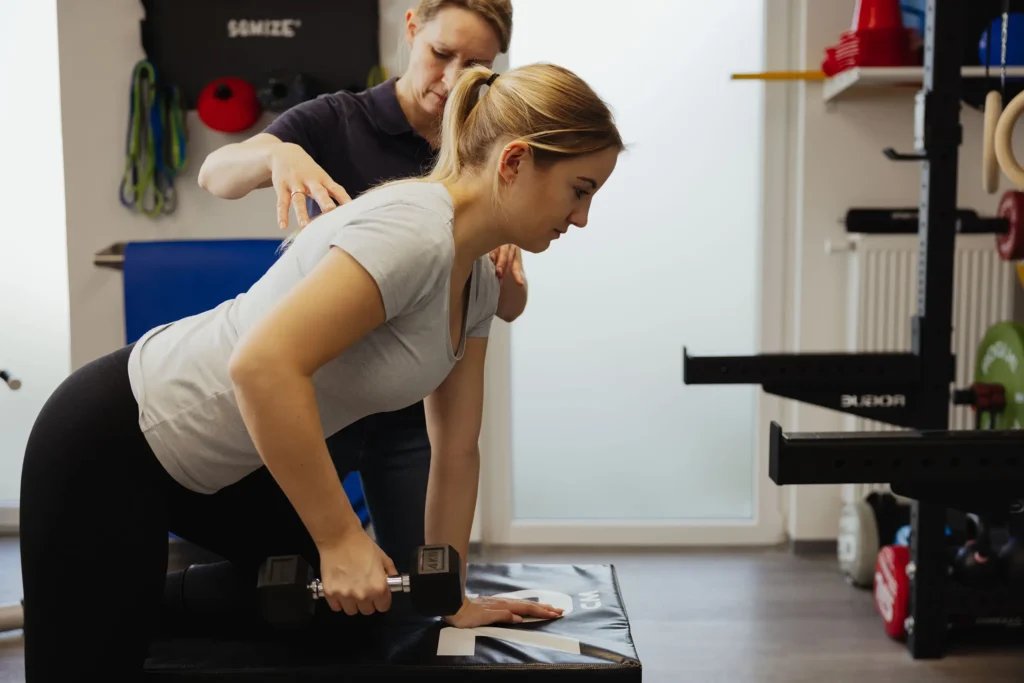 Diana Ambrassat hilft Patientin bei der Form einer Übung als Präventionstraining bei Rückenbeschwerden